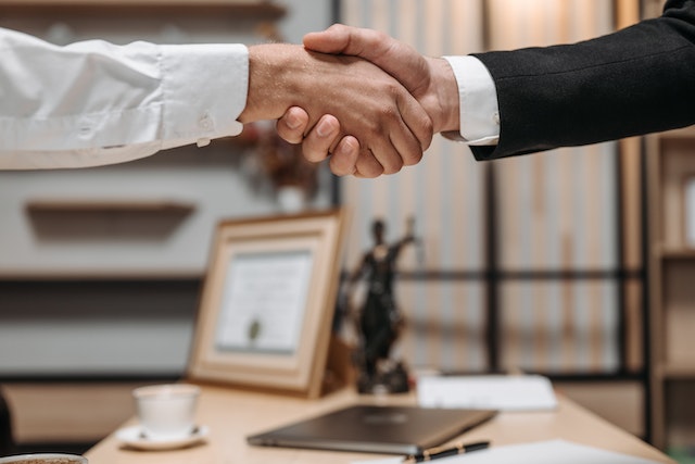 shaking hands over a desk